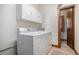 Practical laundry room equipped with a washer, dryer, and overhead cabinets for storage at 1888 Kelvin Dr, Lawrenceville, GA 30043