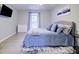 Comfortable bedroom features a cozy bed with blue bedding, soft rug, and a flat-screen TV at 24317 Plantation Ne Dr, Atlanta, GA 30324