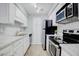 Modern kitchen featuring stainless steel appliances, white cabinets, and ample counter space at 24317 Plantation Ne Dr, Atlanta, GA 30324