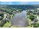 Aerial view showcasing a large lake surrounded by trees, with homes nestled along the shoreline at 3517 Ridgemill Cir, Dacula, GA 30019