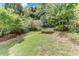 Lush backyard with tiered landscaping, mature trees, and a grassy area at 3517 Ridgemill Cir, Dacula, GA 30019