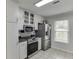 Kitchen featuring stainless appliances, tile floors, and white cabinetry at 376 Paula Ct, Lawrenceville, GA 30046