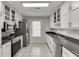 Galley kitchen with stainless steel appliances and plentiful white cabinets and drawers at 376 Paula Ct, Lawrenceville, GA 30046