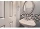 Half-bath featuring a stylish mosaic backsplash and white pedestal sink at 3807 Cyrus Ridge Nw Way, Kennesaw, GA 30152