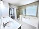 Bright bathroom featuring double vanity, garden tub, shower, and window providing natural light at 4056 Kingsley Park Ct, Peachtree Corners, GA 30096