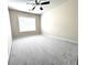 Bright and airy bedroom with soft gray carpet, neutral walls, ceiling fan, and a large window at 4056 Kingsley Park Ct, Peachtree Corners, GA 30096
