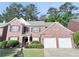 Charming two-story brick home featuring a well-maintained lawn, manicured shrubs and a two car garage at 4056 Kingsley Park Ct, Peachtree Corners, GA 30096