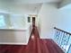 Second-floor hallway featuring gleaming hardwood floors, neutral walls, and elegant railing, leading to multiple rooms at 4056 Kingsley Park Ct, Peachtree Corners, GA 30096
