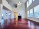 Expansive living room with soaring ceilings, fireplace, large windows, and hardwood floors, creating an airy atmosphere at 4056 Kingsley Park Ct, Peachtree Corners, GA 30096