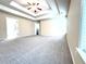 Spacious main bedroom featuring plush carpet, tray ceiling with ceiling fan, and neutral walls at 4056 Kingsley Park Ct, Peachtree Corners, GA 30096