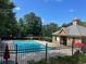 Community pool featuring a fenced-in area and lounge chairs with a charming pool house at 4056 Kingsley Park Ct, Peachtree Corners, GA 30096
