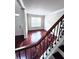 View of hardwood staircase with decorative iron railings and foyer; natural light from window at 4056 Kingsley Park Ct, Peachtree Corners, GA 30096