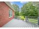 The back deck features brick exterior and gray wood flooring, an excellent spot for relaxation and enjoying nature at 516 Main St, Hiram, GA 30141