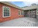 Large back deck showcases gray wood flooring and brick exterior, creating an inviting outdoor living space at 516 Main St, Hiram, GA 30141