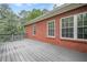 Spacious back deck features brick exterior and gray wood flooring, ideal for entertaining or relaxing outdoors at 516 Main St, Hiram, GA 30141