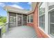 Charming back deck with gray wood flooring and brick exterior, adjacent to a screened porch for versatile outdoor enjoyment at 516 Main St, Hiram, GA 30141