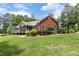 Brick home with a charming screened porch, complemented by manicured landscaping and a spacious lawn at 516 Main St, Hiram, GA 30141