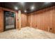 Basement with carpeted floors and wooden walls with access to outside through glass door at 516 Main St, Hiram, GA 30141
