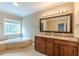 Bathroom with double vanity, granite countertop, soaking tub, and large mirror at 516 Main St, Hiram, GA 30141