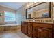Bathroom featuring double sinks, granite countertop, and large soaking tub at 516 Main St, Hiram, GA 30141