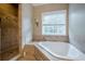 Bathroom featuring a soaking tub, tiled shower, and a large window at 516 Main St, Hiram, GA 30141