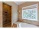 Bathroom with tiled walk-in shower and soaking tub near a window at 516 Main St, Hiram, GA 30141