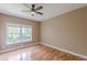 Bedroom with hardwood floors, a ceiling fan, and a large window, showcasing natural light at 516 Main St, Hiram, GA 30141