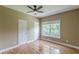 Bedroom with hardwood floors, a ceiling fan, and a window with blinds, offering privacy at 516 Main St, Hiram, GA 30141