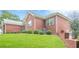 Beautiful brick home with green grass, landscaping, and a large grassy yard at 516 Main St, Hiram, GA 30141
