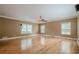 Bright living room with hardwood floors, ceiling fan, and three large windows at 516 Main St, Hiram, GA 30141