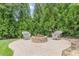 Relaxing stone patio with chairs nestled amongst trees at 516 Main St, Hiram, GA 30141