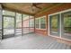 Relax on the screened porch with brick exterior, gray wood flooring, and natural light, perfect for enjoying outdoor living at 516 Main St, Hiram, GA 30141