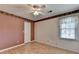 Empty bedroom with wood laminate floors, a ceiling fan, a window, and baseboard trim at 1464 Yorktown Nw Dr, Lawrenceville, GA 30043