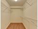 Walk-in closet featuring custom organizers and wood laminate floors at 1464 Yorktown Nw Dr, Lawrenceville, GA 30043