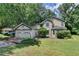 Charming traditional home featuring a two-car garage, manicured lawn, mature trees, and lots of curb appeal at 1464 Yorktown Nw Dr, Lawrenceville, GA 30043