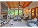 Relaxing back porch with a stone fireplace, comfortable seating, and natural wood ceiling at 3510 Woodbury Creek Dr, Cumming, GA 30041