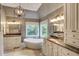 Elegant bathroom with dual sinks, soaking tub, and travertine tile flooring at 3510 Woodbury Creek Dr, Cumming, GA 30041