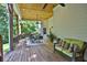 Cozy screened porch features a ceiling fan, comfortable wicker sofa with pillows, and a dining table at 3510 Woodbury Creek Dr, Cumming, GA 30041