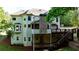 Rear exterior showing two-story deck, stone chimney, and ample natural light at 3510 Woodbury Creek Dr, Cumming, GA 30041