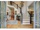 Grand foyer featuring hardwood floors, staircase, and decorative glass front doors at 3510 Woodbury Creek Dr, Cumming, GA 30041