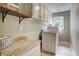Bright laundry room with granite countertops, overhead cabinets, and modern washer and dryer at 3510 Woodbury Creek Dr, Cumming, GA 30041