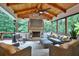 Comfortable porch with a stone fireplace, wood ceiling, ceiling fan and comfortable seating at 3510 Woodbury Creek Dr, Cumming, GA 30041