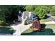 Aerial view of home showcasing a spacious driveway, lush greenery, and mature trees at 3510 Woodbury Creek Dr, Cumming, GA 30041