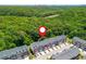 Aerial view of townhomes with garages surrounded by lush trees and a distant city skyline backdrop at 3799 Chattahoochee Summit Se Dr # 5, Atlanta, GA 30339