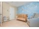 Charming Bedroom with blue floral accent wall, wooden crib, gray rocking chair, and a book display at 3799 Chattahoochee Summit Se Dr # 5, Atlanta, GA 30339