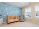 Cozy Bedroom featuring blue floral wallpaper, wooden crib, and a comfortable gray rocking chair at 3799 Chattahoochee Summit Se Dr # 5, Atlanta, GA 30339