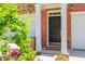 Inviting front door with sidelights and brick facade, enhanced by colorful landscaping and an attached garage at 3799 Chattahoochee Summit Se Dr # 5, Atlanta, GA 30339