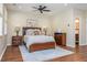 Bright main bedroom with wood floors, ceiling fan, a comfortable bed, and an ensuite bathroom at 3799 Chattahoochee Summit Se Dr # 5, Atlanta, GA 30339