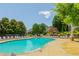 Community pool with plenty of lounge chairs and umbrellas, surrounded by green trees and shrubbery at 3799 Chattahoochee Summit Se Dr # 5, Atlanta, GA 30339