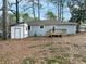 Back exterior of home featuring a shed, wooden deck, and foliage yard at 551 Floyd Se Dr, Smyrna, GA 30082
